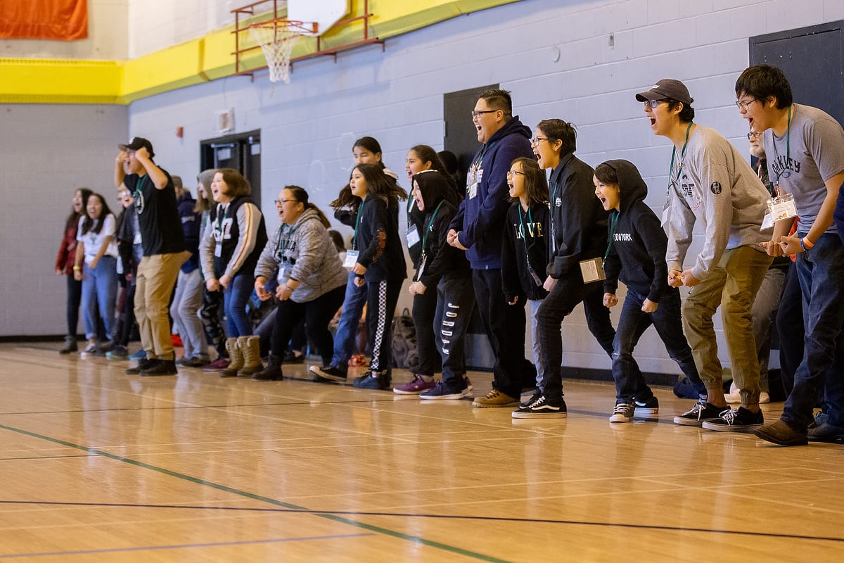 A group of students make noise during a game in a Resiliency Summit session.