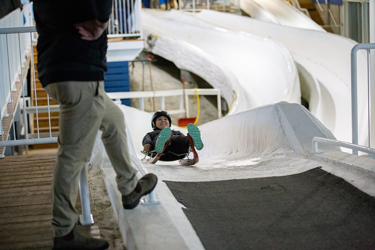 A student smiles while experiencing the Ice Luge at Winsport, one of the wellness break options of the Resiliency Summit.