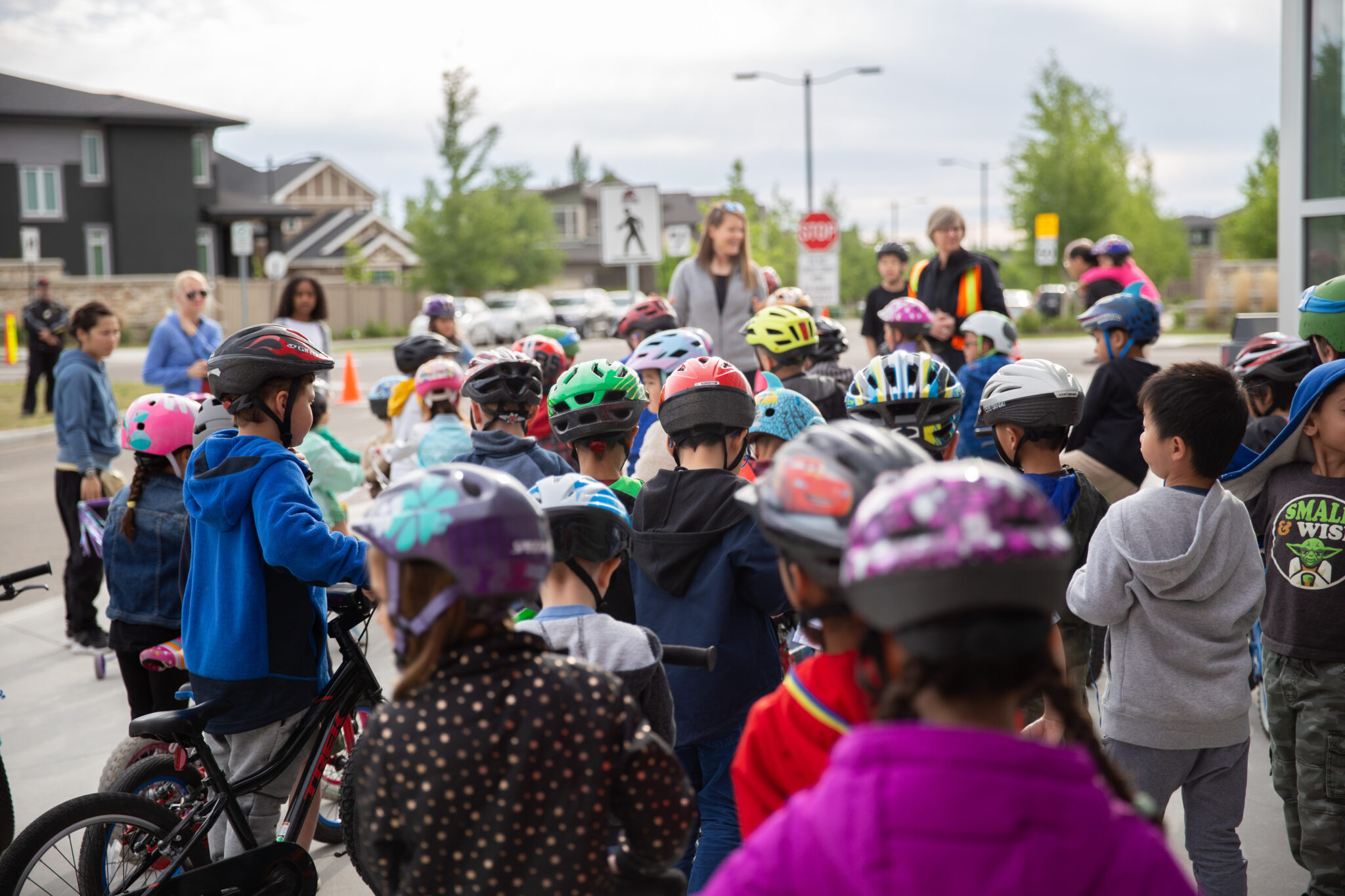 A group of children wearing colourful cycling helmets.