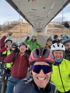 a group of winter cyclists taking a selfie on a bridge