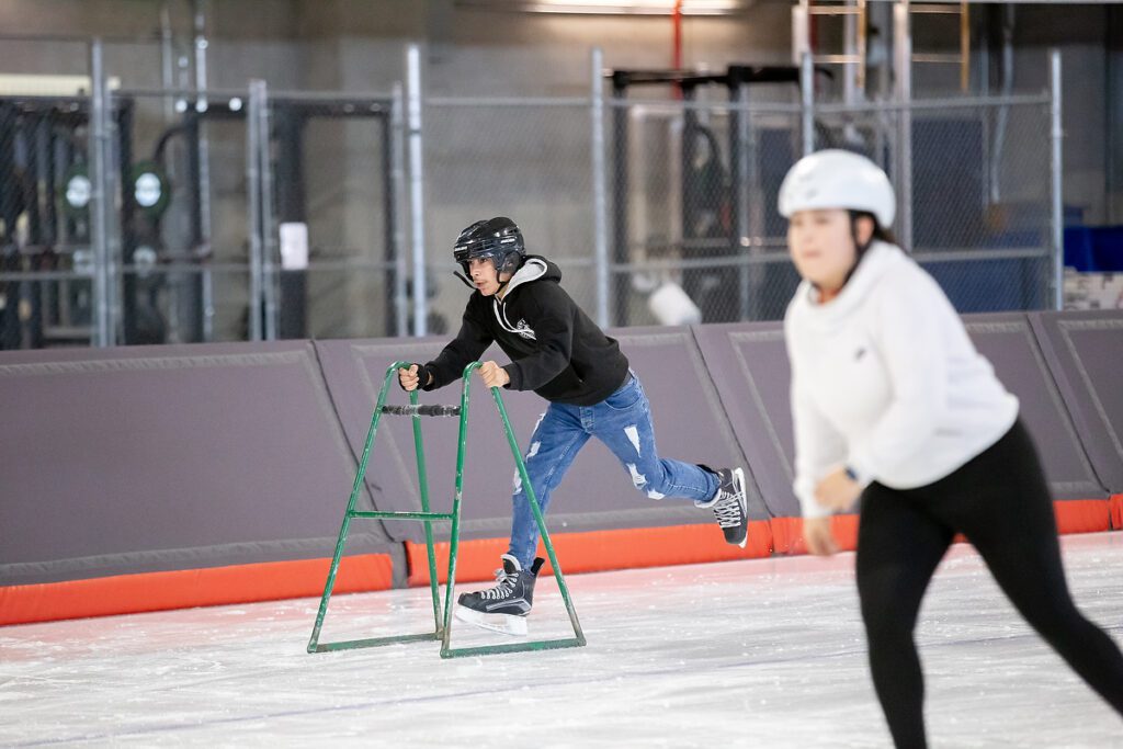 A boy running in skates on ice with a support to lean on as part of the Canadian Outdoor Experience project