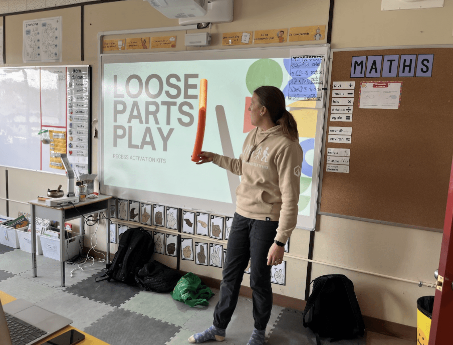 teacher in classroom pointing to board