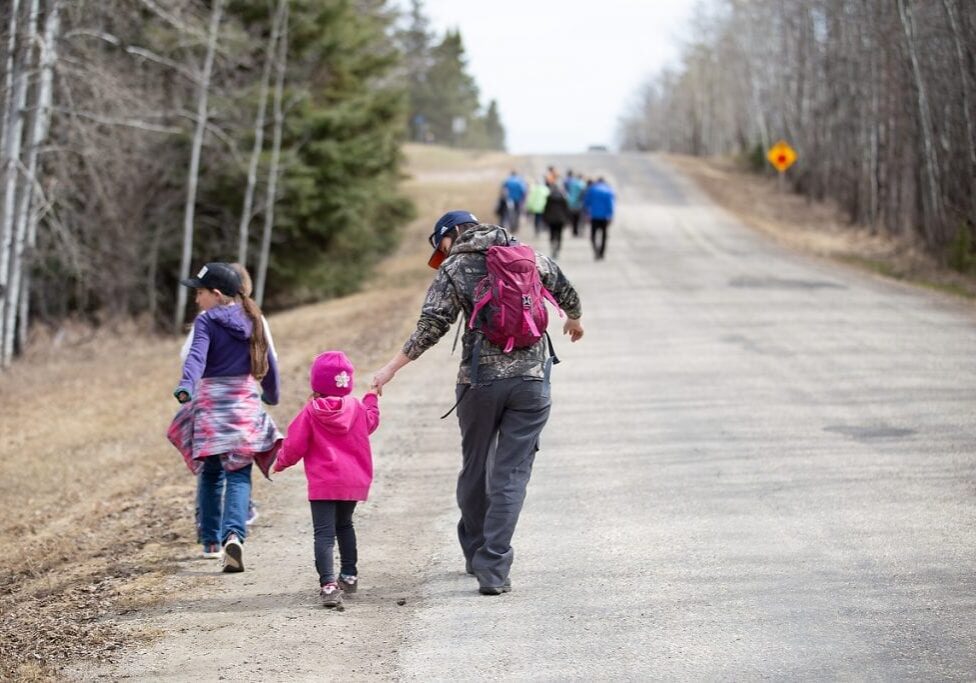 An adult walking a child down a street in an active travel session